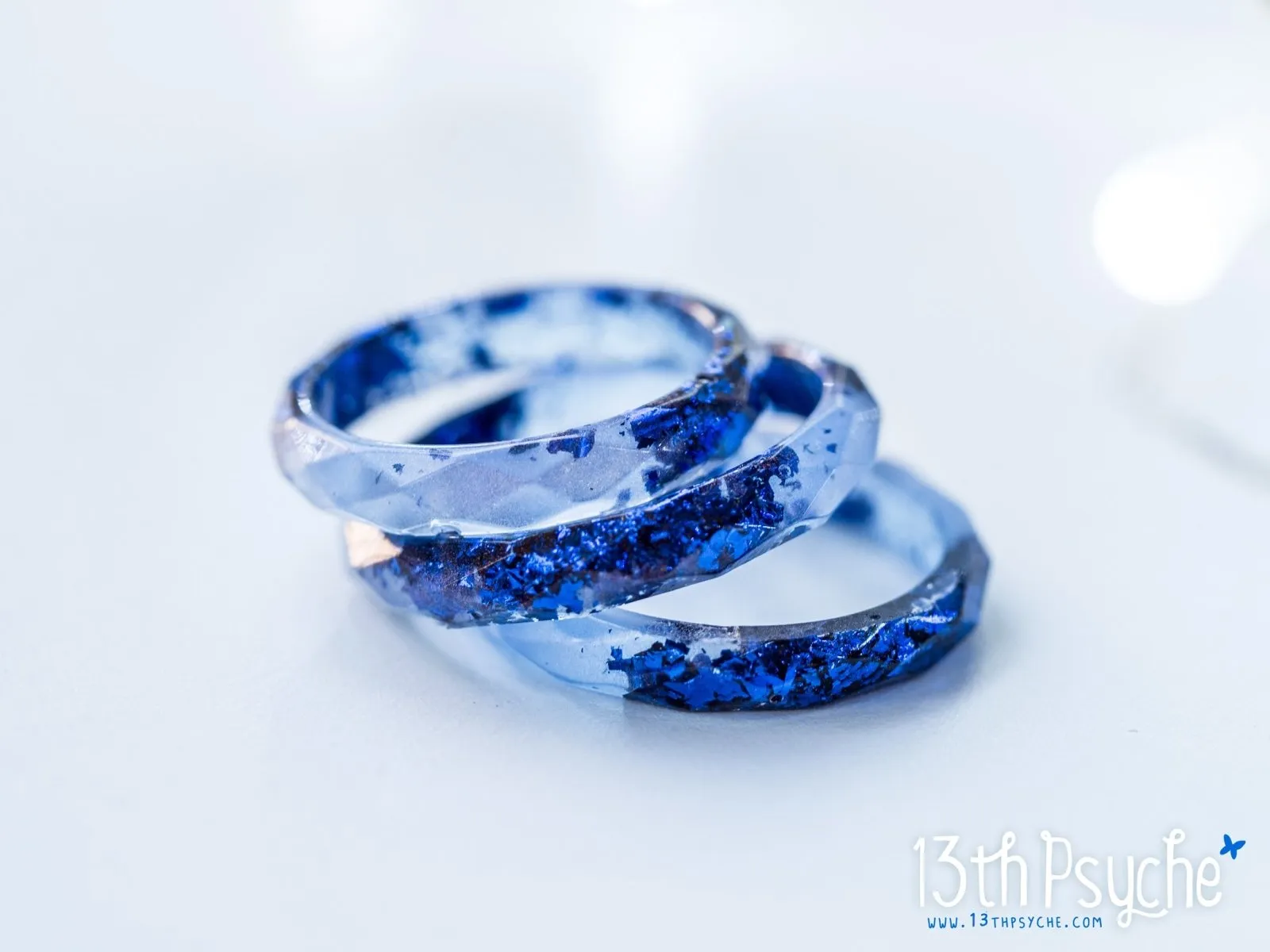 Light blue faceted resin ring with blue flakes